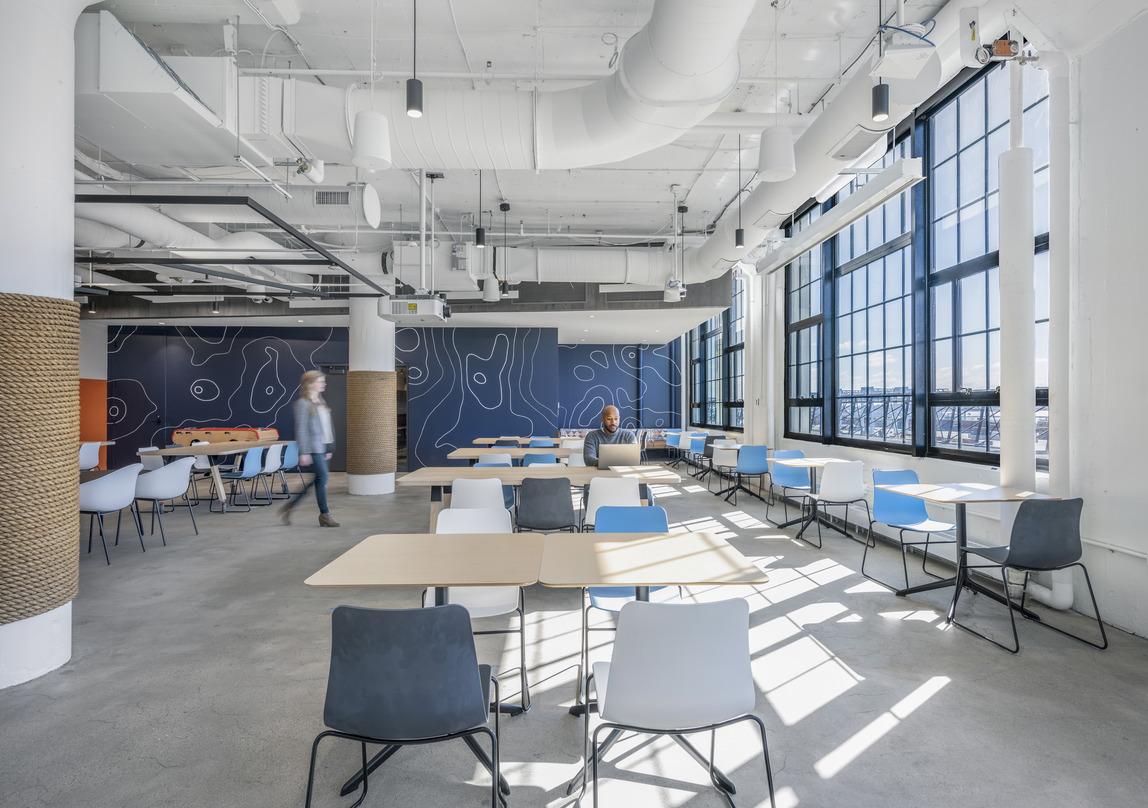 Cafe area in Veson Nautical office, featuring calming blue topographic wallpaper